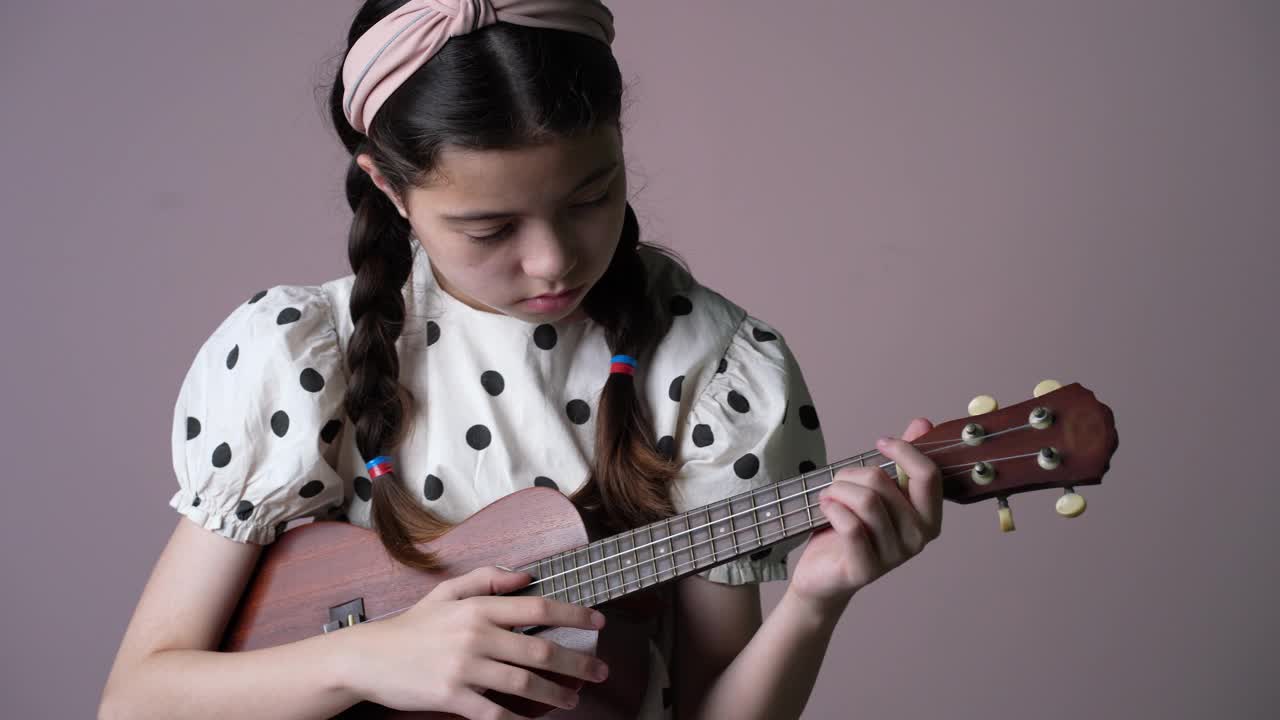 女孩练习尤克里里琴。视频下载