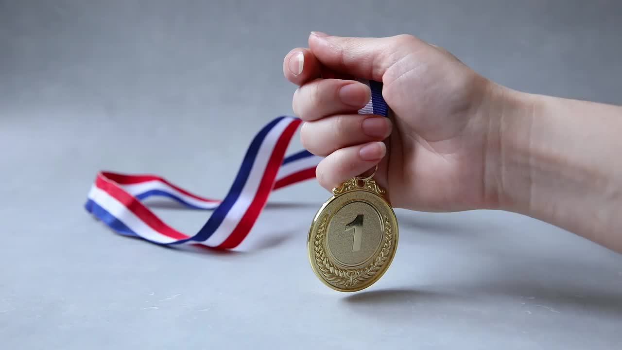 手握冠军或冠军金质奖杯奖牌在水泥石灰色背景。获得比赛第一名。胜利或成功理念视频下载