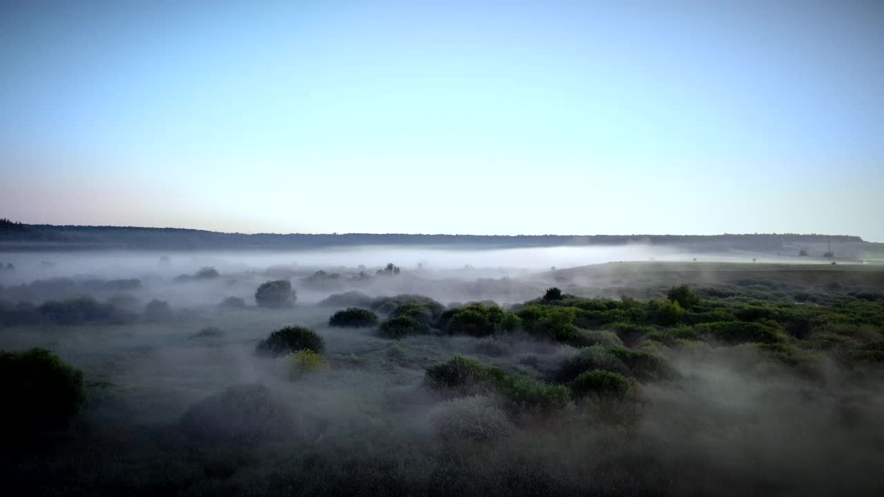 一架无人机从清晨的雾霭中鸟瞰这片神秘的风景。视频下载