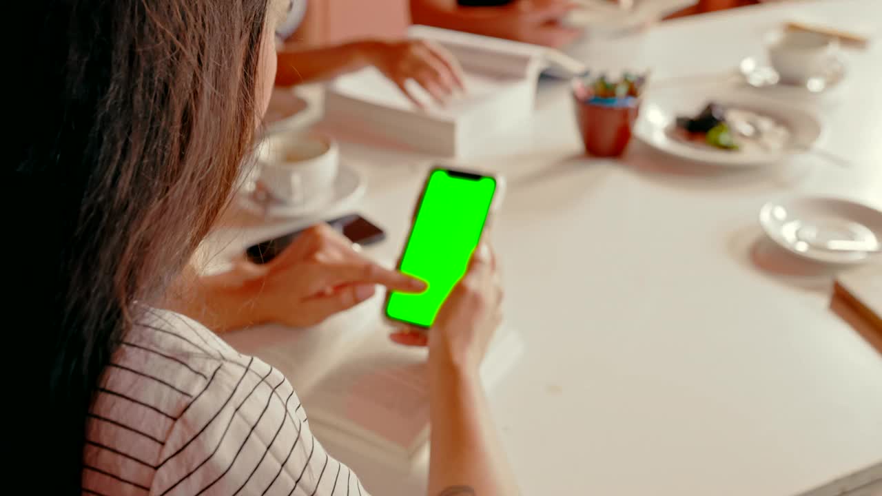 一段4k视频记录了一个陌生女人在咖啡馆看书时用手机的画面视频素材