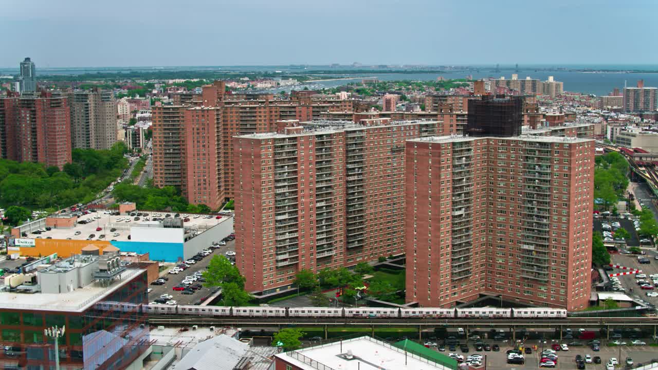 静态无人机拍摄的高架列车通过公寓大楼在科尼岛，纽约视频下载