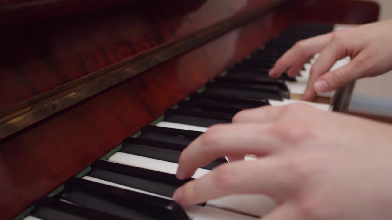 女手弹钢琴，特写，侧视。缓慢的运动。演奏乐器和古典音乐的概念视频素材