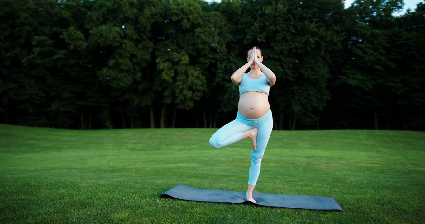 怀孕的白人妇女在户外练习瑜伽健身视频素材