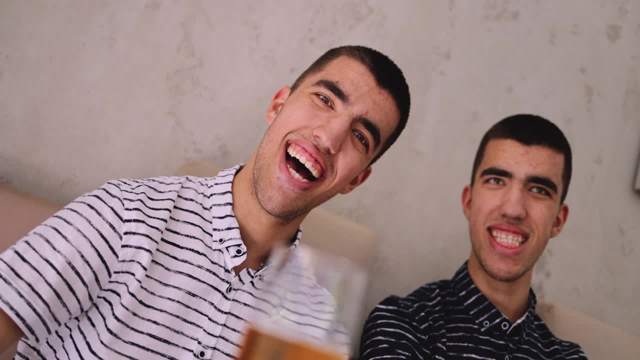 一模一样的双胞胎兄弟笑着看着相机的照片视频下载