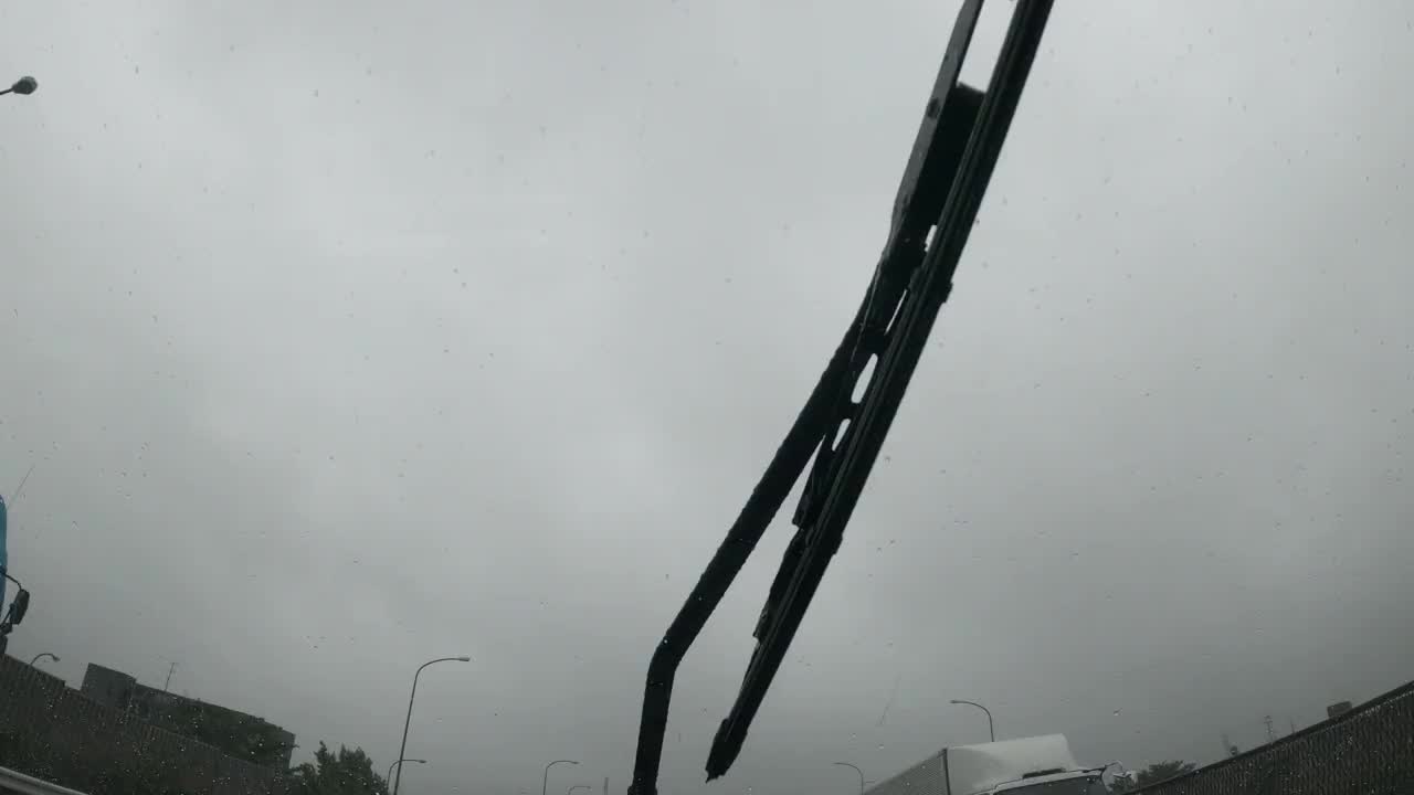 雨刮器在阴天驾驶时清洗汽车挡风玻璃上的雨水视频素材