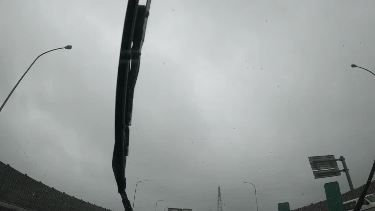雨刮器在阴天驾驶时清洗汽车挡风玻璃上的雨水视频素材