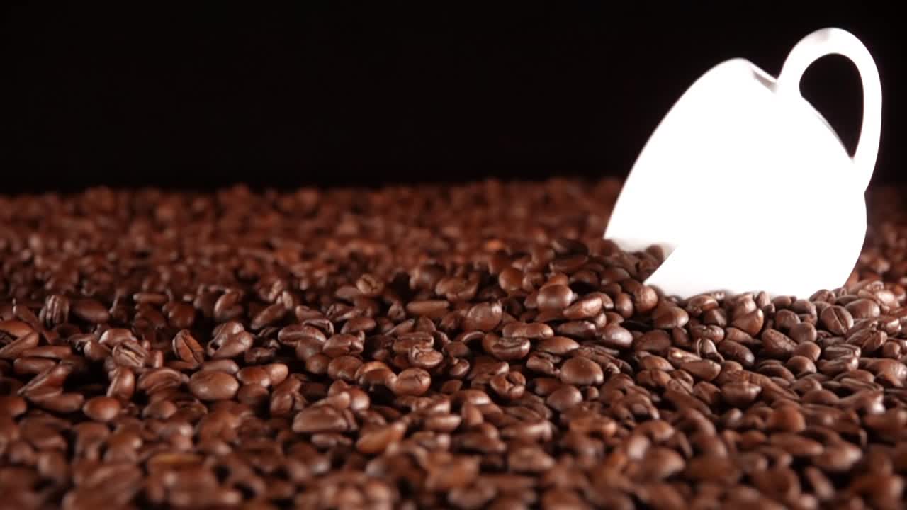 从一堆白色的杯子中取出咖啡豆。慢动作视频素材