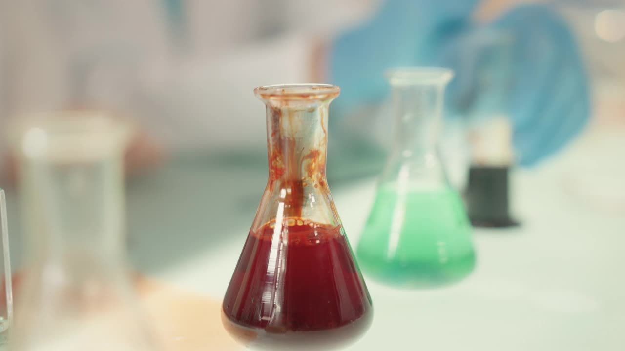 孩子们在实验室里做科学实验。用移液管浇注多种颜色的液体。近距离视频素材