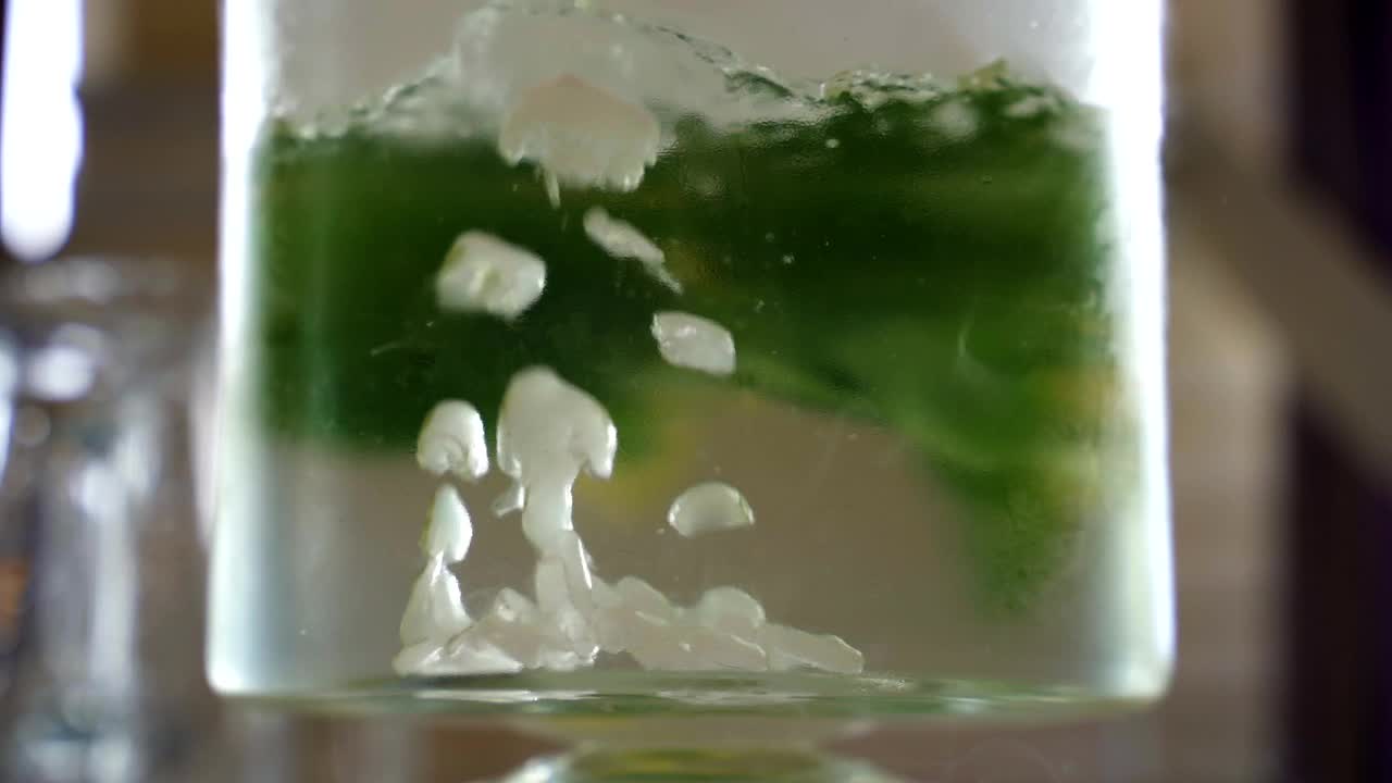 用慢动作拍摄的气泡在柠檬和薄荷柠檬柠檬汁的冰苏打水和干冰准备饮用视频素材