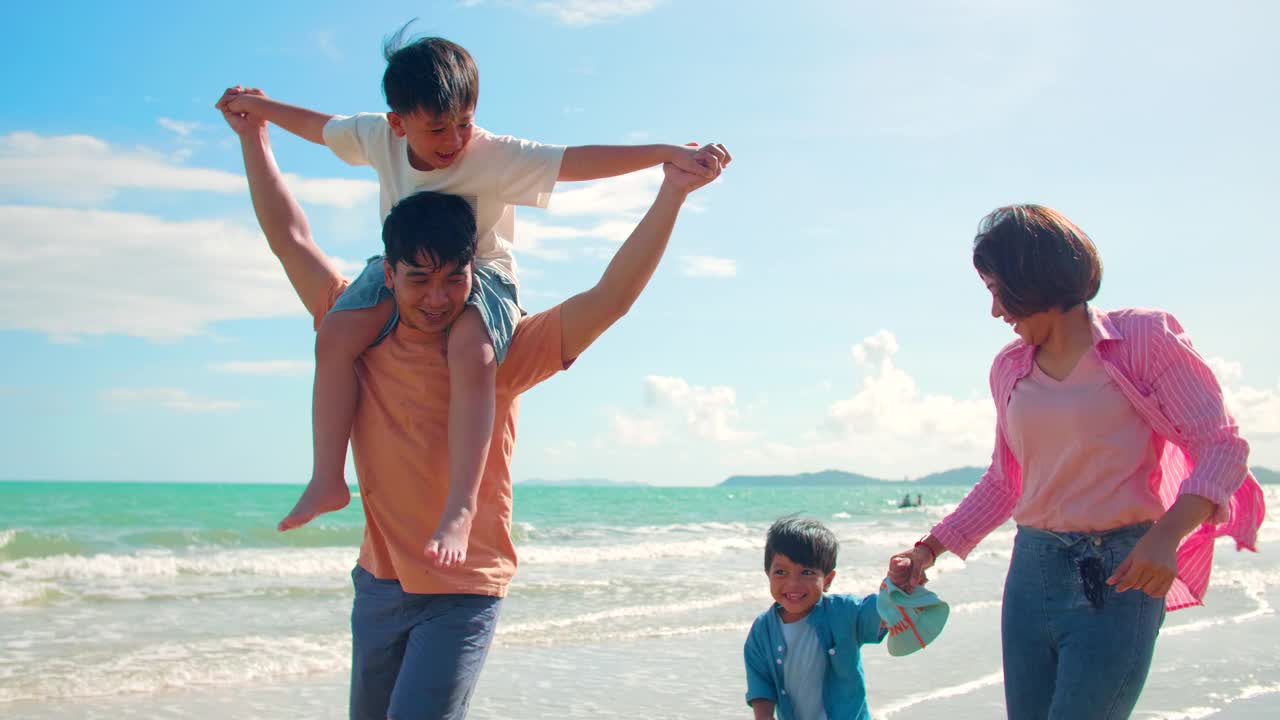 快乐的亚洲家庭在沙滩上奔跑视频素材