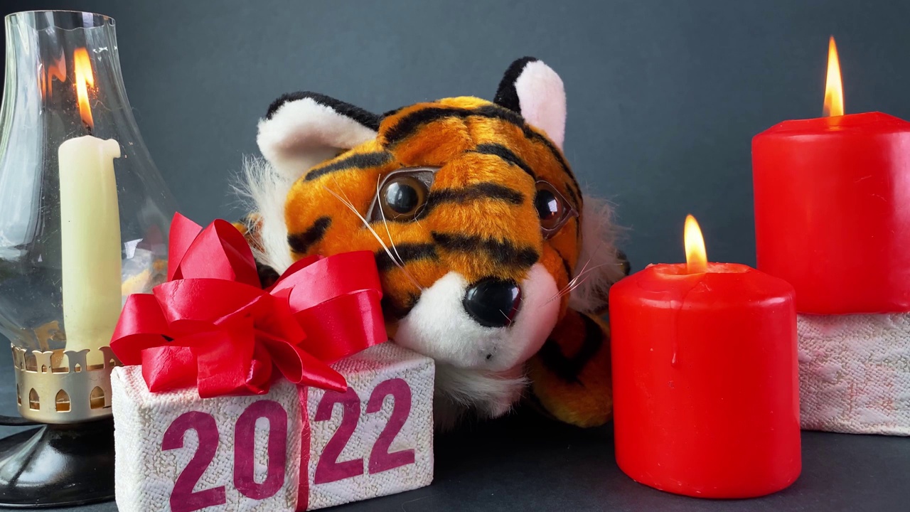 老虎象征2022年，燃烧的蜡烛和印有2022字样的礼盒视频下载