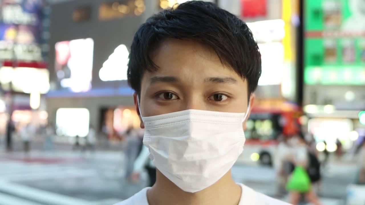 戴着防护口罩的微笑亚洲青年男子肖像视频素材