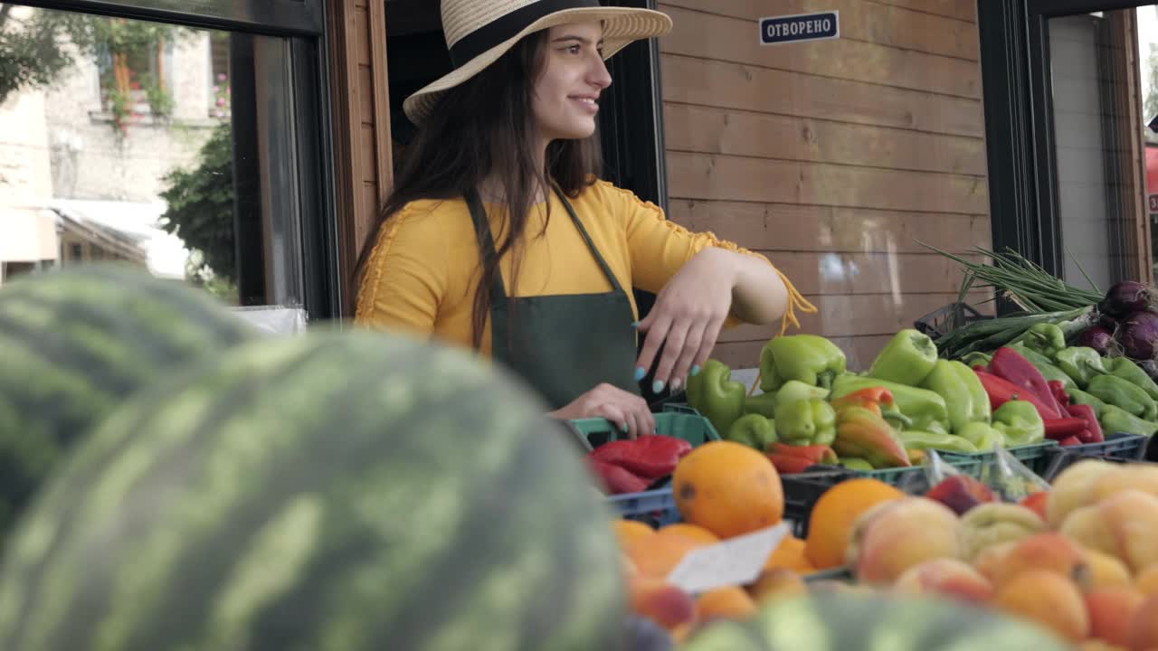 开朗的女蔬菜水果商在农贸市场提供本地产品视频素材