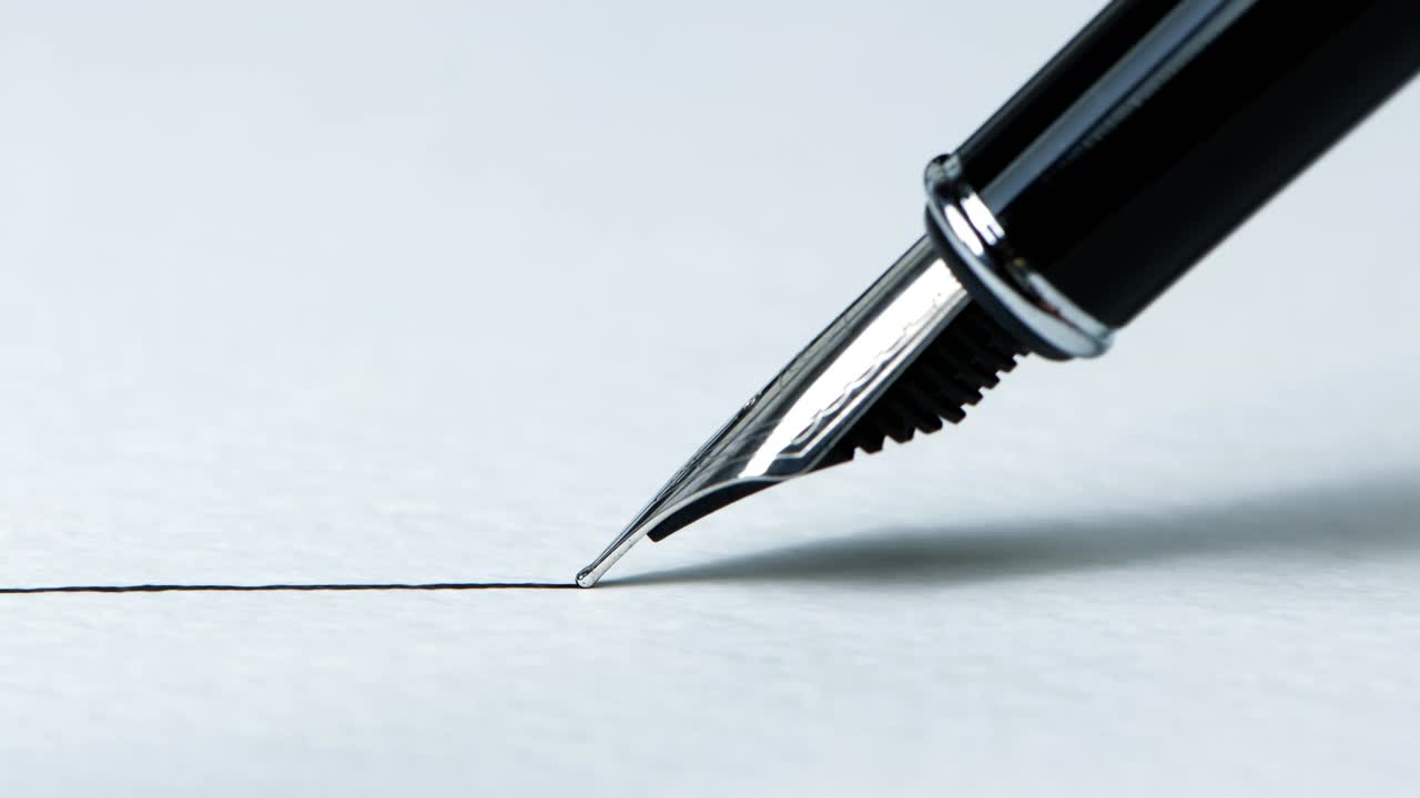 特写镜头:一支钢笔在有纹理的纸上画出一条笔直的墨线视频下载