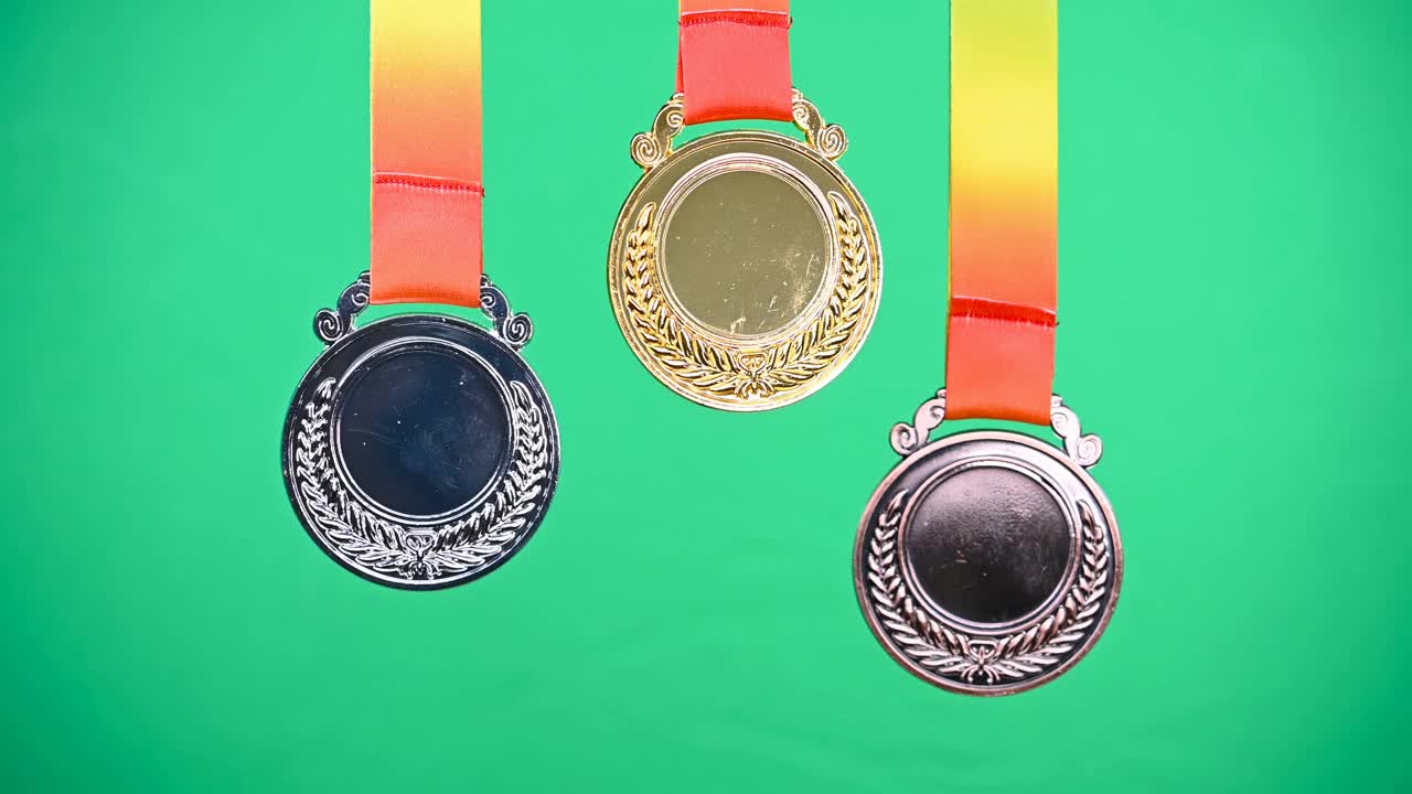 一套金牌，银牌和铜奖奖牌在一个绿色的背景视频下载