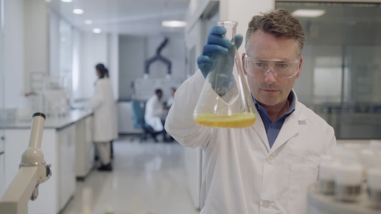 男科学家在实验室里观察锥形烧瓶样本视频下载