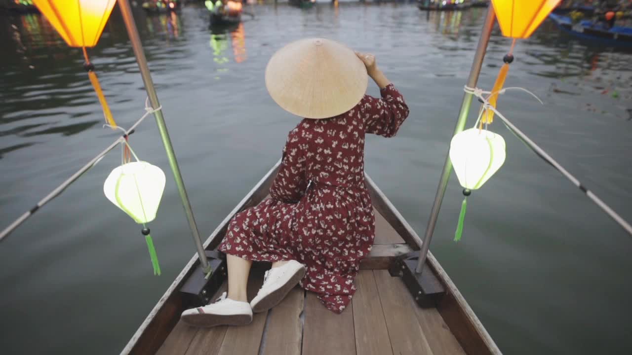 会安元宵节，船上的年轻女子戴着越南传统的帽子视频下载