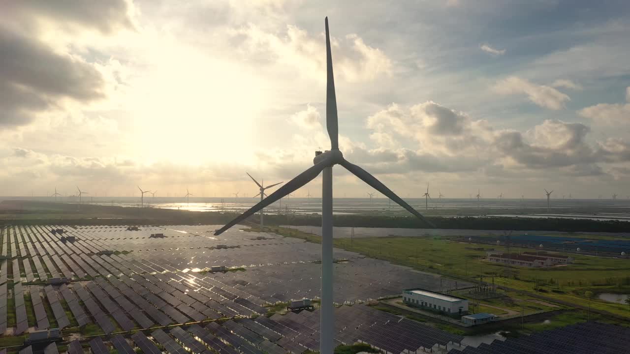 高大的风力涡轮机正在运转，地面上的太阳能发电站也在运转。中国江苏省盐城市视频下载