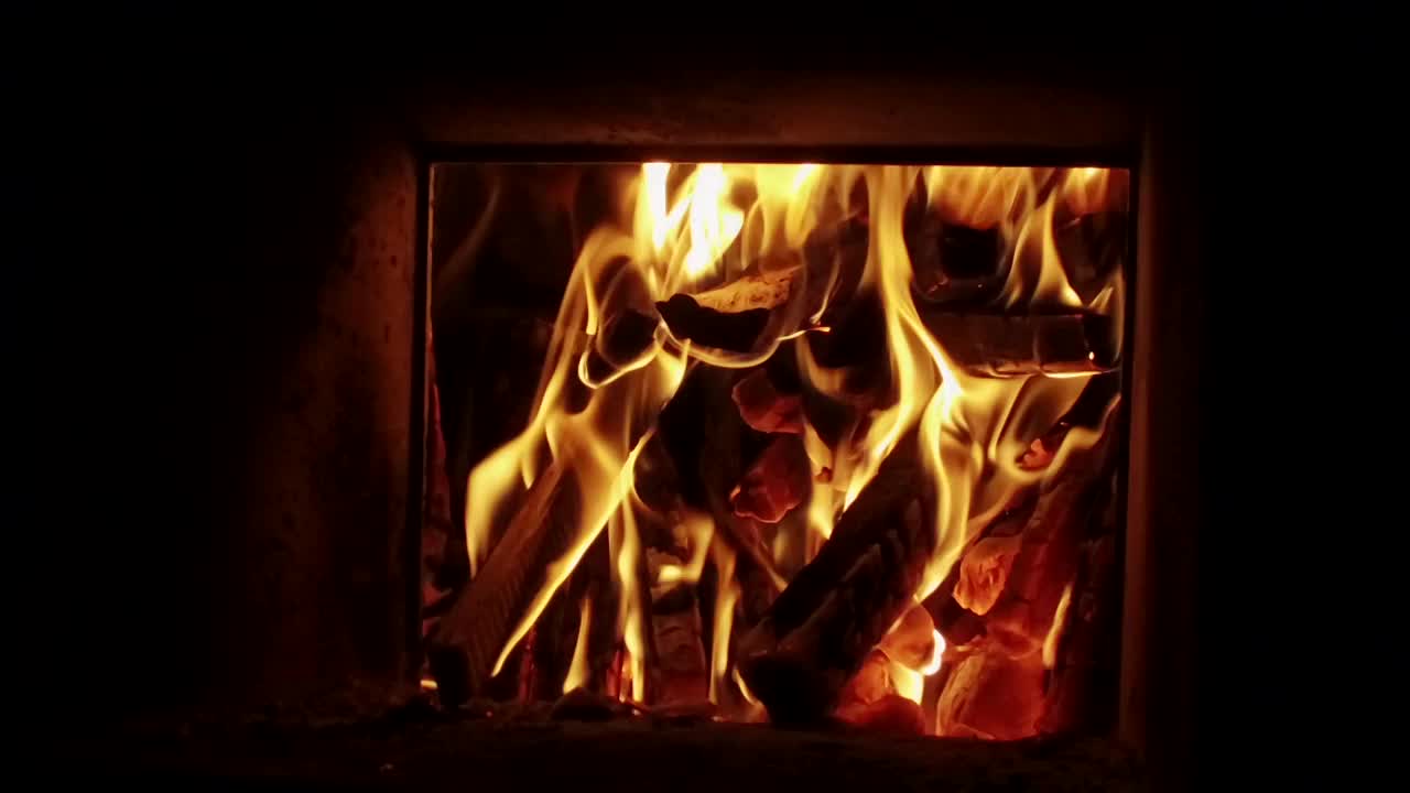 近距离拍摄温暖舒适燃烧的火在砖壁炉。缓慢的运动。高清视频下载