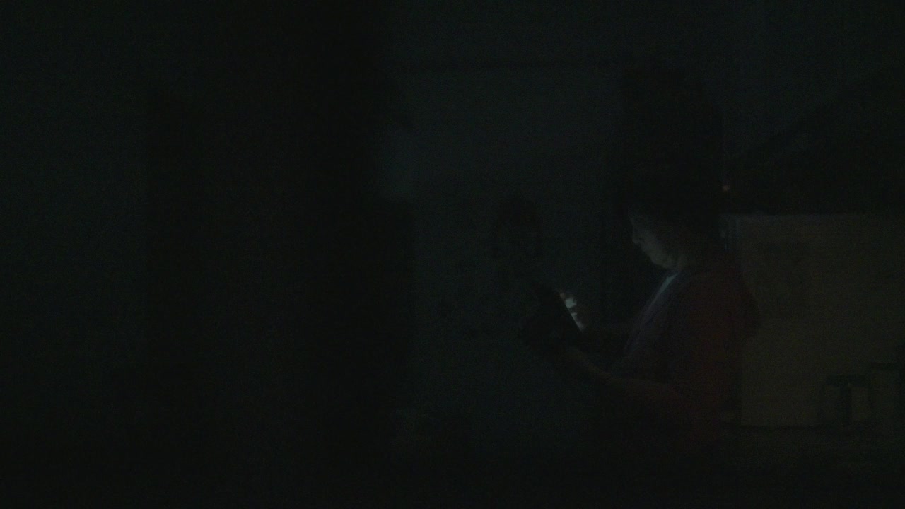 亚洲华人高级妇女在深夜使用数码平板电脑上网和在家庭厨房饮水视频下载