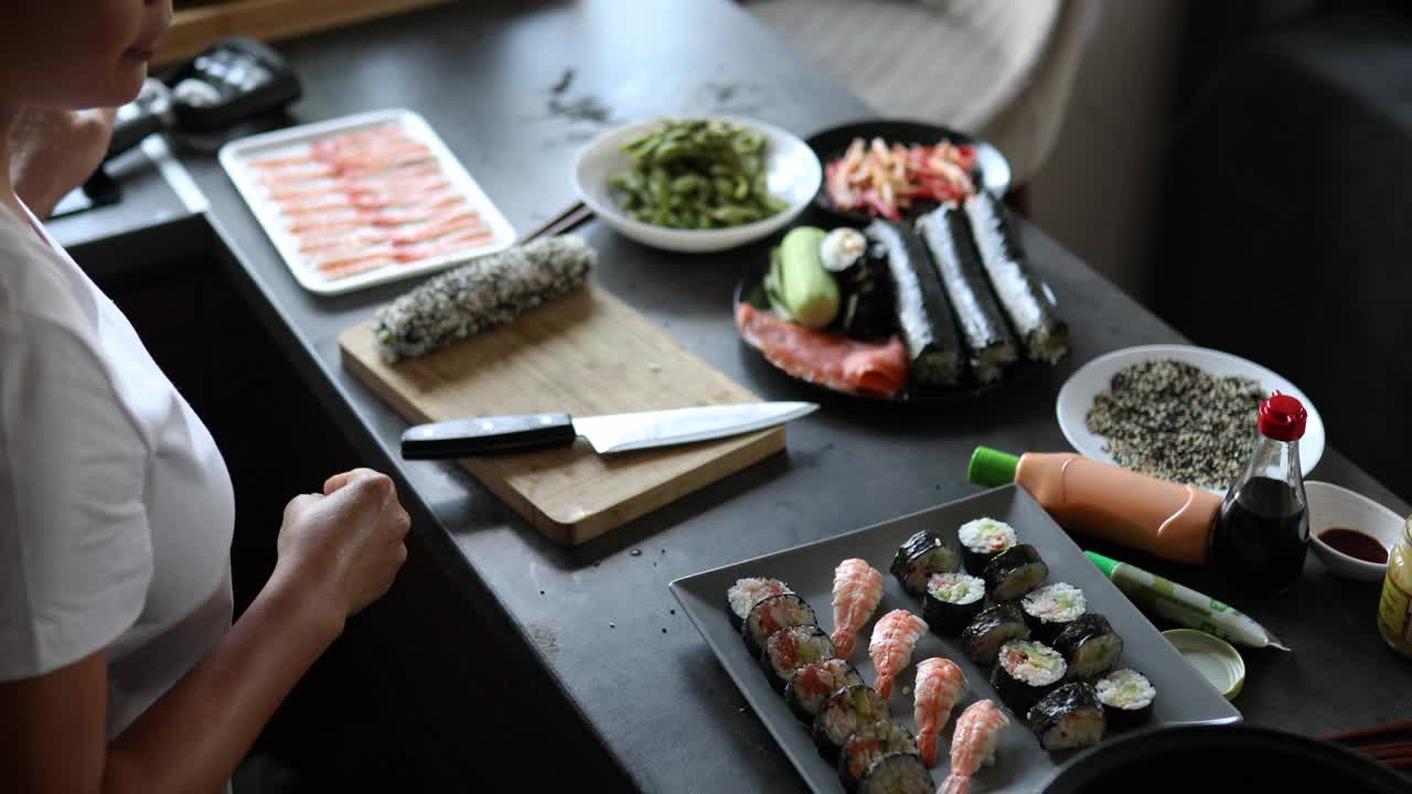 女人用手握寿司卷，普通寿司卷和里外寿司卷布置和装饰盘子视频下载
