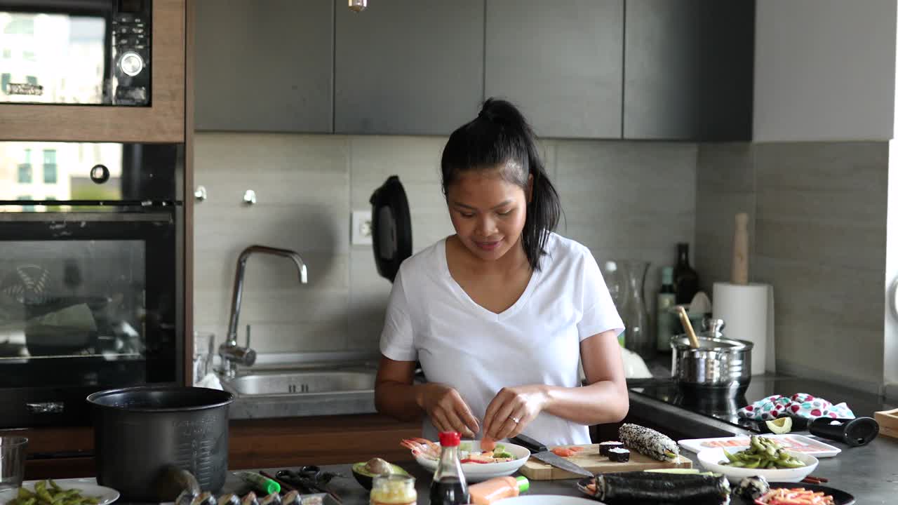一名泰国女子正准备用鳄梨、黄瓜、虾和烟熏鲑鱼配菜视频下载