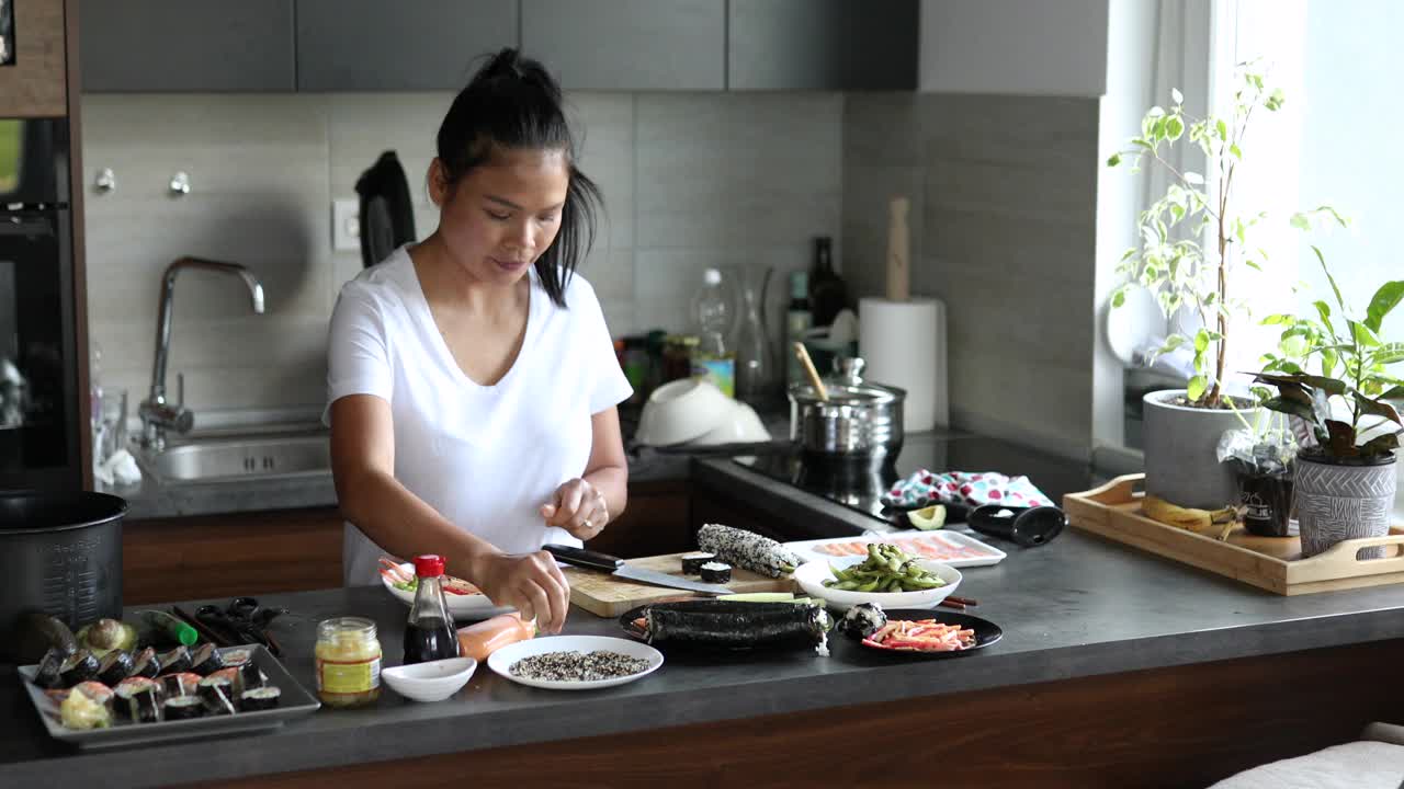 自豪的女寿司厨师，展示着配菜的盘子，配寿司卷很好视频下载