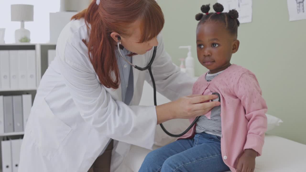 一个医生用听诊器给一个可爱的小女孩做检查的4k视频视频素材