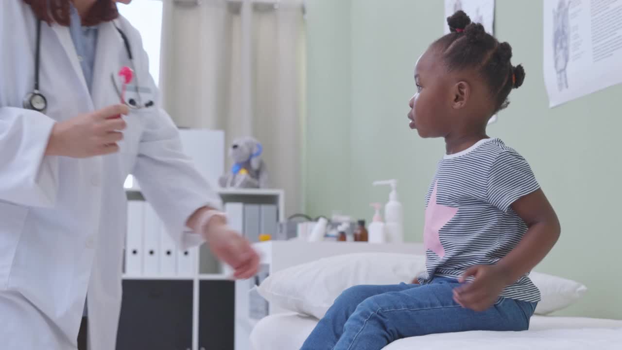 一段4k视频记录了一个可爱的小女孩在体检时从医生那里得到棒棒糖的过程视频素材