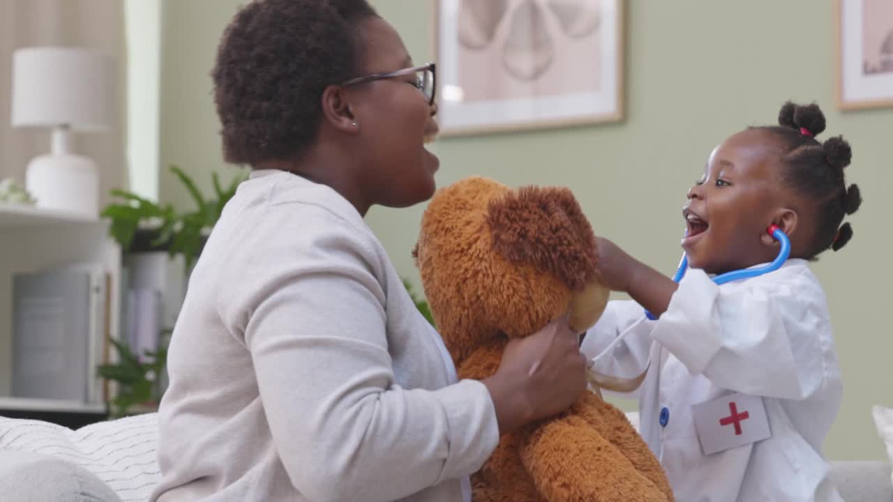 4k视频记录了一个小女孩穿着医生服在家里和她的妈妈和泰迪熊玩耍的画面视频下载