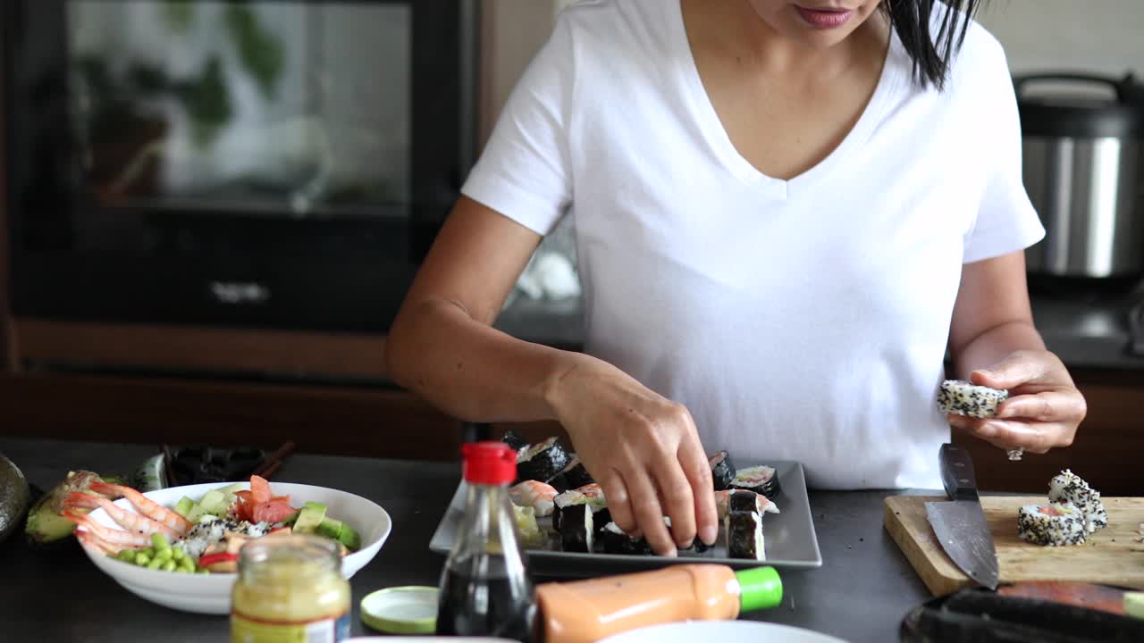女寿司师傅用手握寿司和传统寿司卷将寿司卷里外摆放在盘子上视频下载
