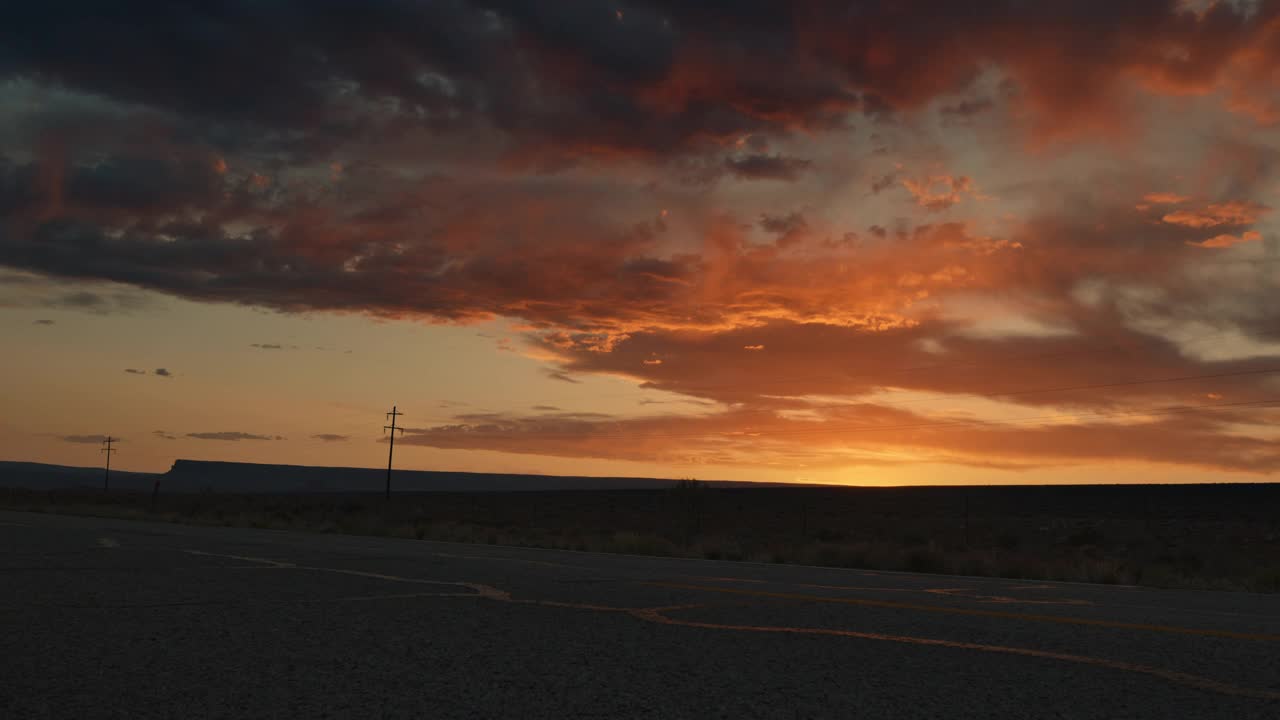 日落时分，空旷的沙漠道路在峡谷地带的犹他州视频下载