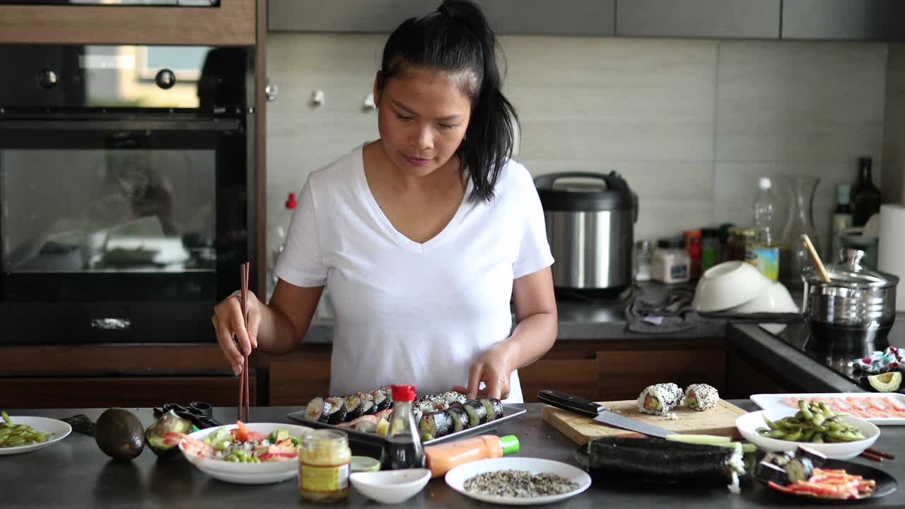 自信和自豪的泰国女子，展示她的寿司盘和手握寿司，传统的寿司卷视频下载