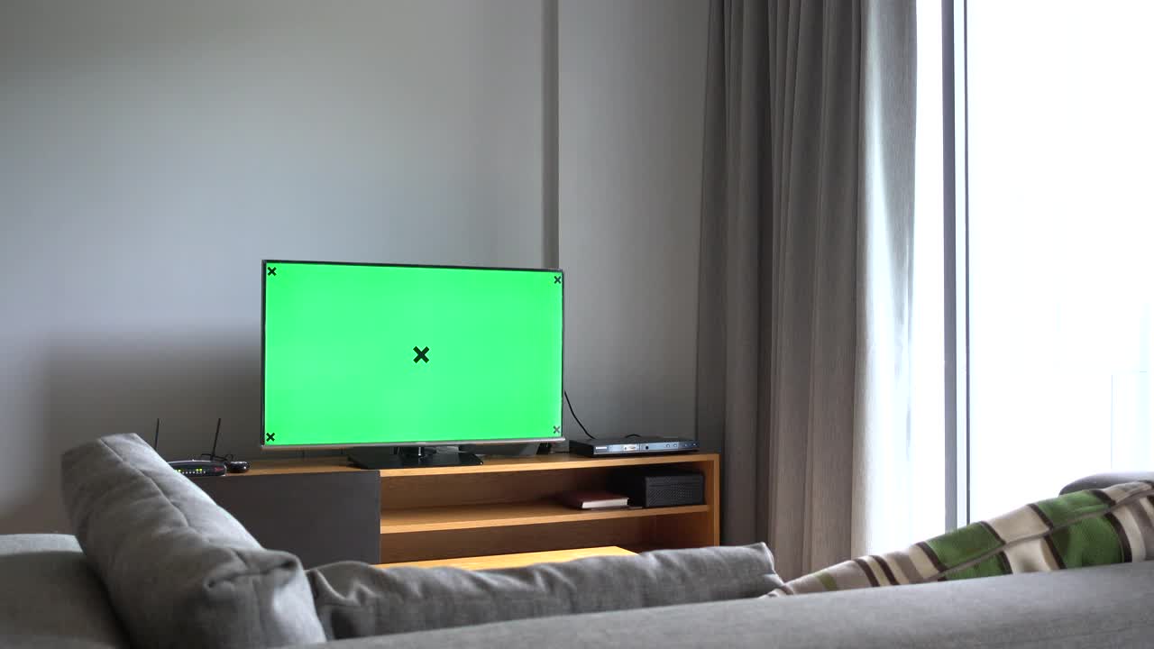 女人在家里看绿色的电视屏幕视频素材