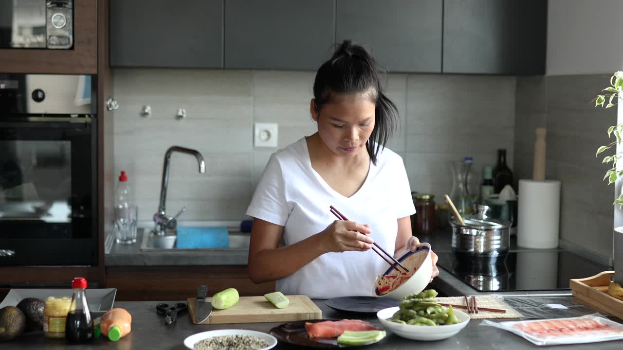 一个泰国女人，在她现代化的家庭厨房里准备寿司的所有原料视频下载