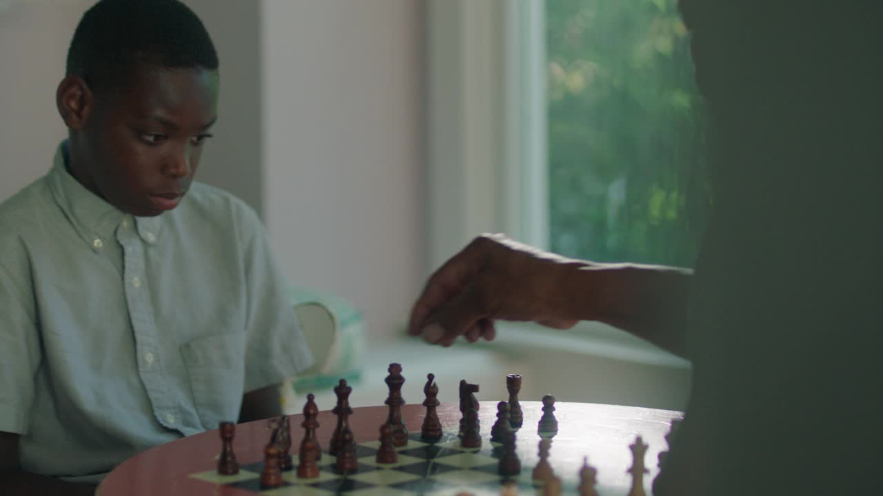 一个小男孩正在学习如何下国际象棋视频素材