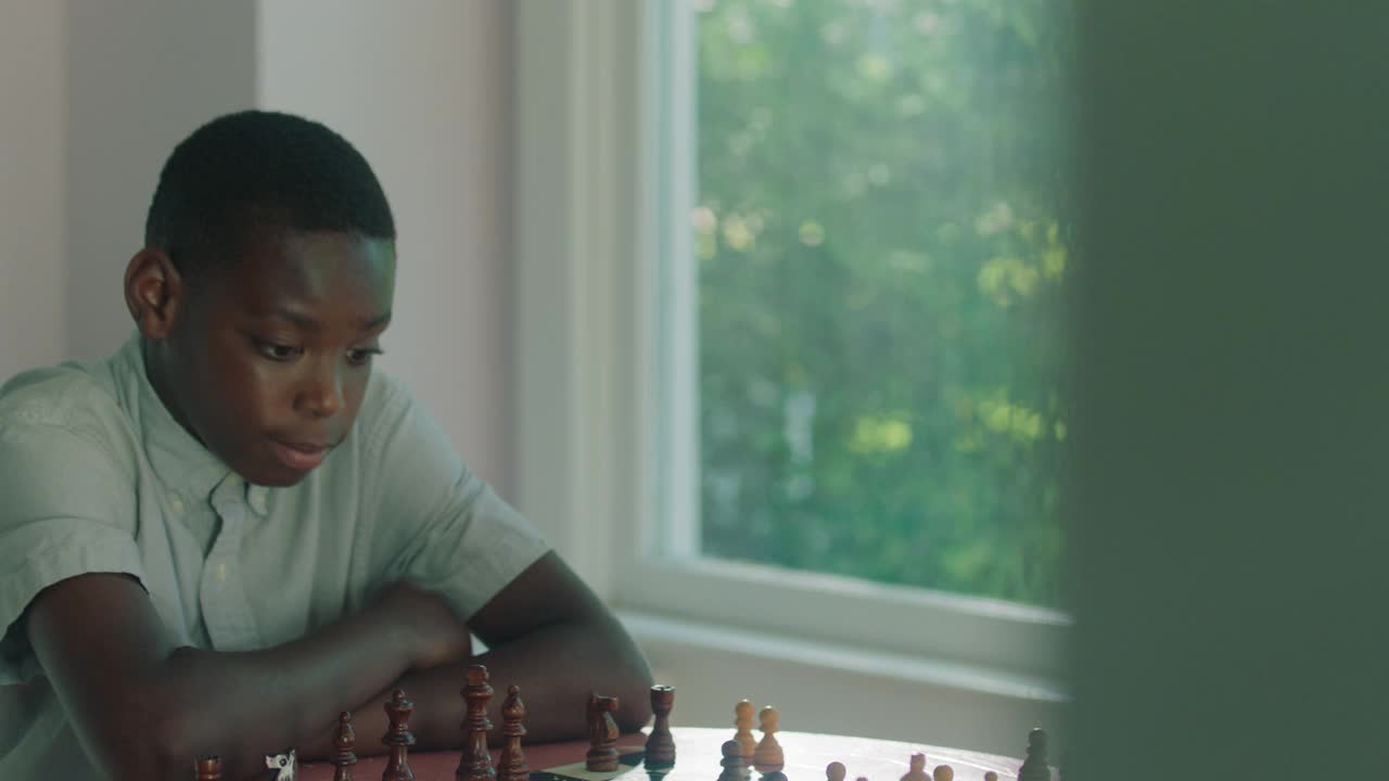 一个小男孩正在学习如何下象棋视频素材