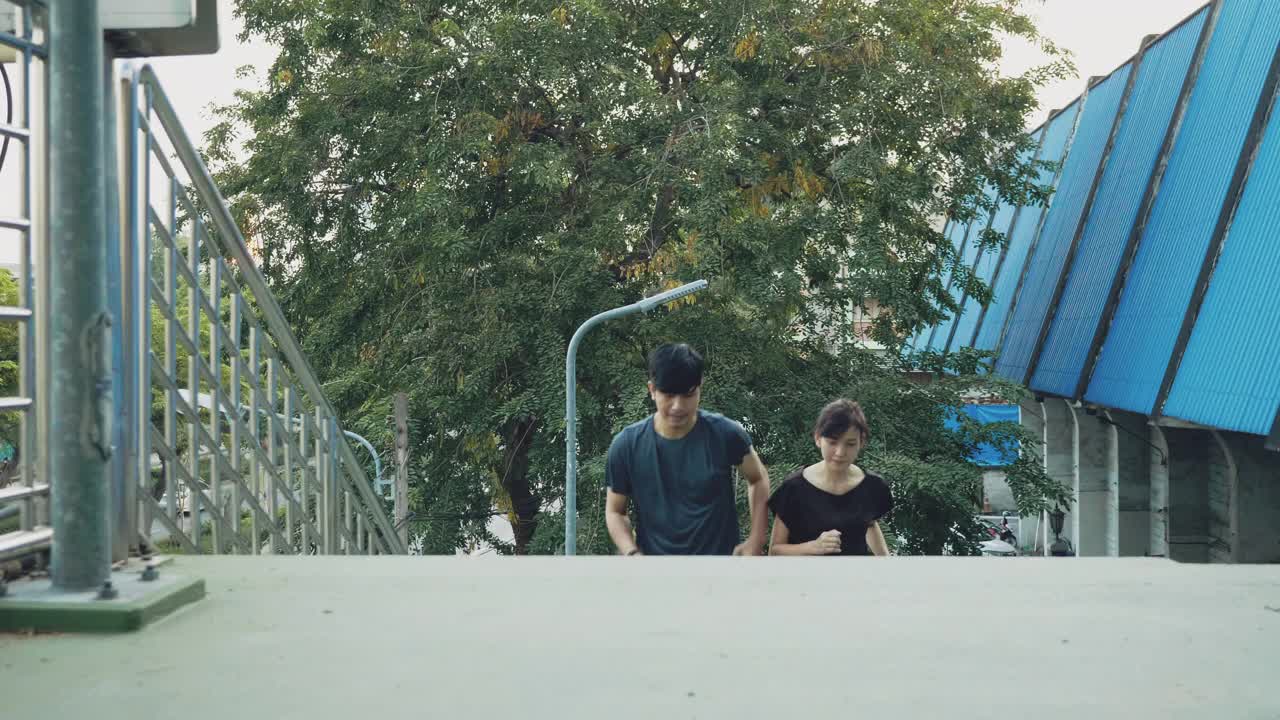 亚洲夫妇在城市里奔跑。视频下载