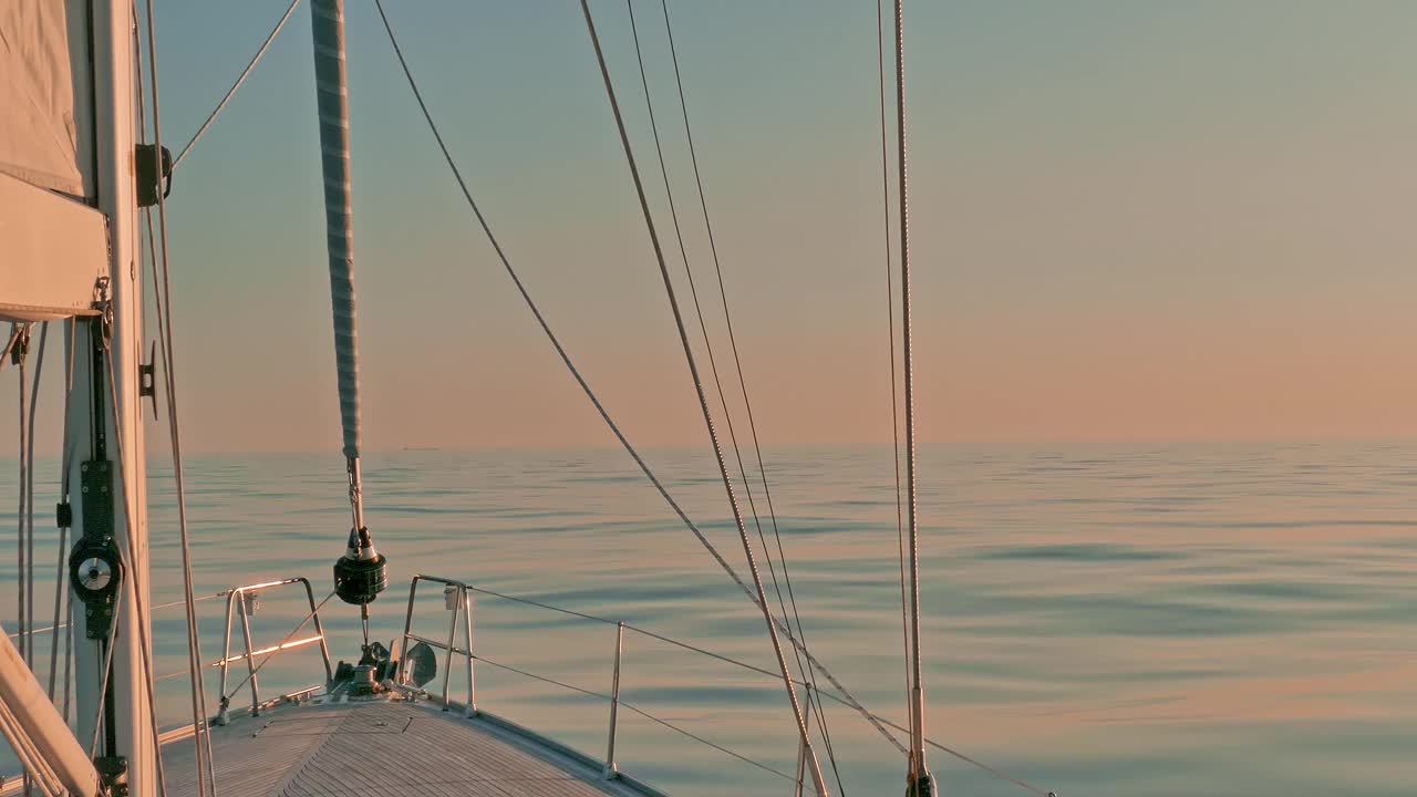 日落时分，加勒比海，风平浪静的海面上，帆船在风平浪静的水面上鞠躬。船帆和帆架视图视频下载