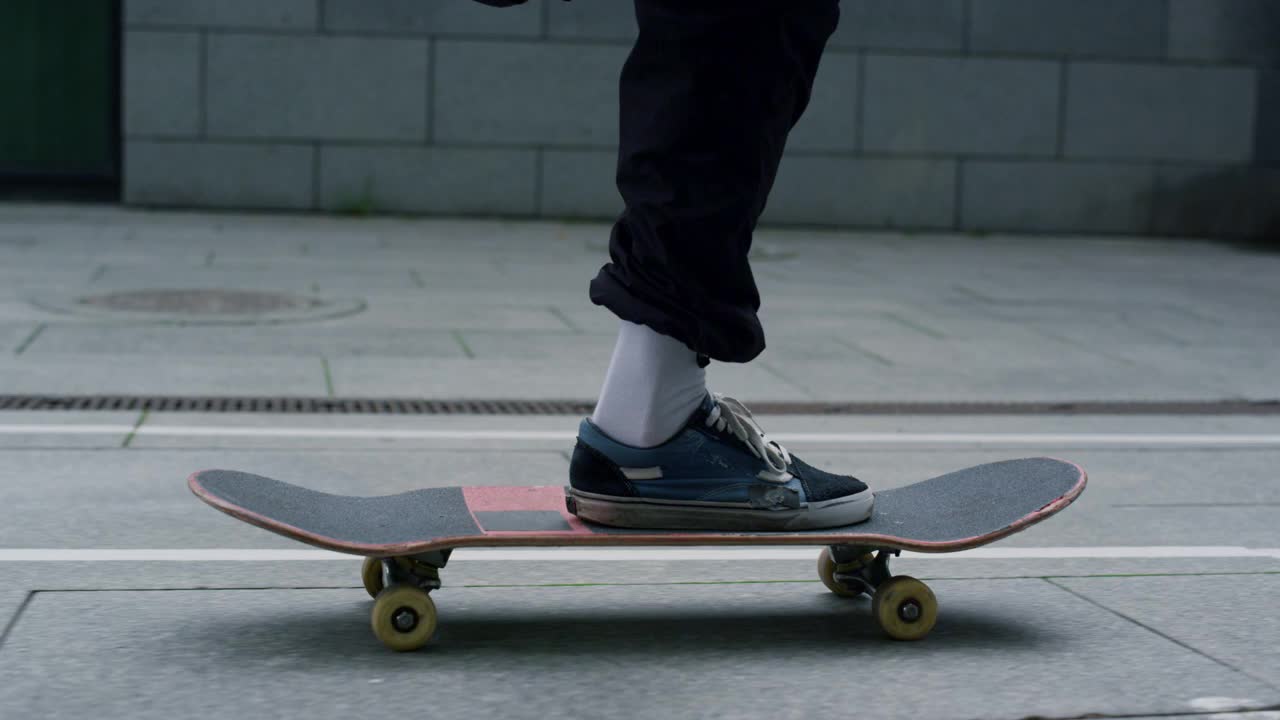 不知名的溜冰者脚踩滑板。嬉皮士在长板上保持平衡。视频下载