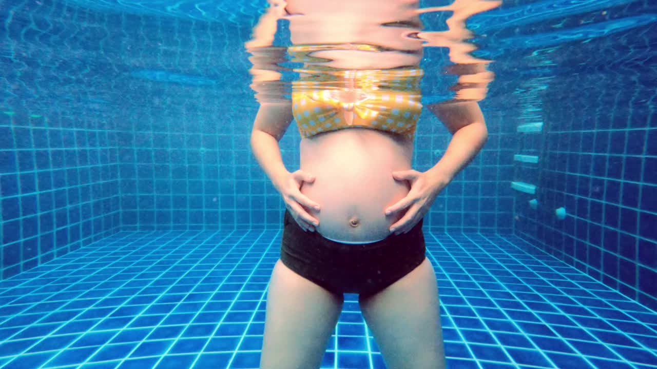 孕妇在游泳池里锻炼。视频下载