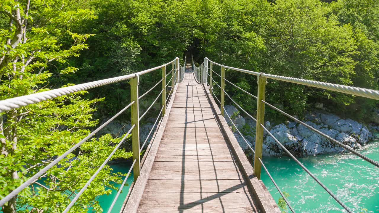 跨越木吊桥，横跨雄伟的绿松石河谷视频下载