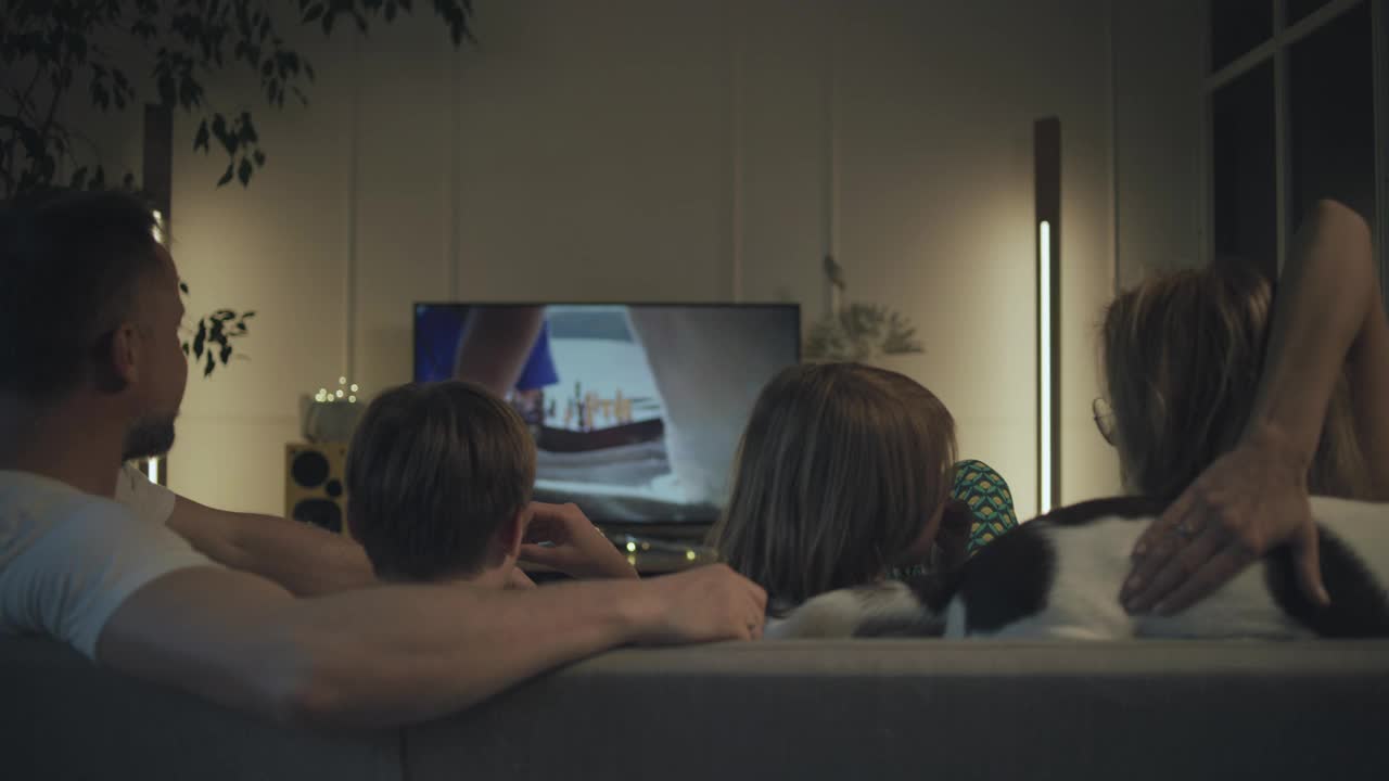 在家看电视。父亲和两个儿子在一起。狗在旁边睡觉视频下载