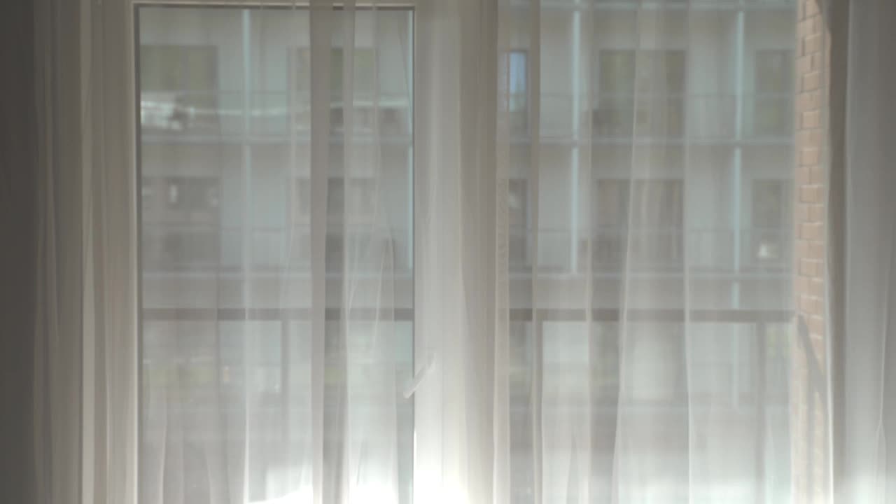 一个女人在酒店房间拉开窗帘。视频素材
