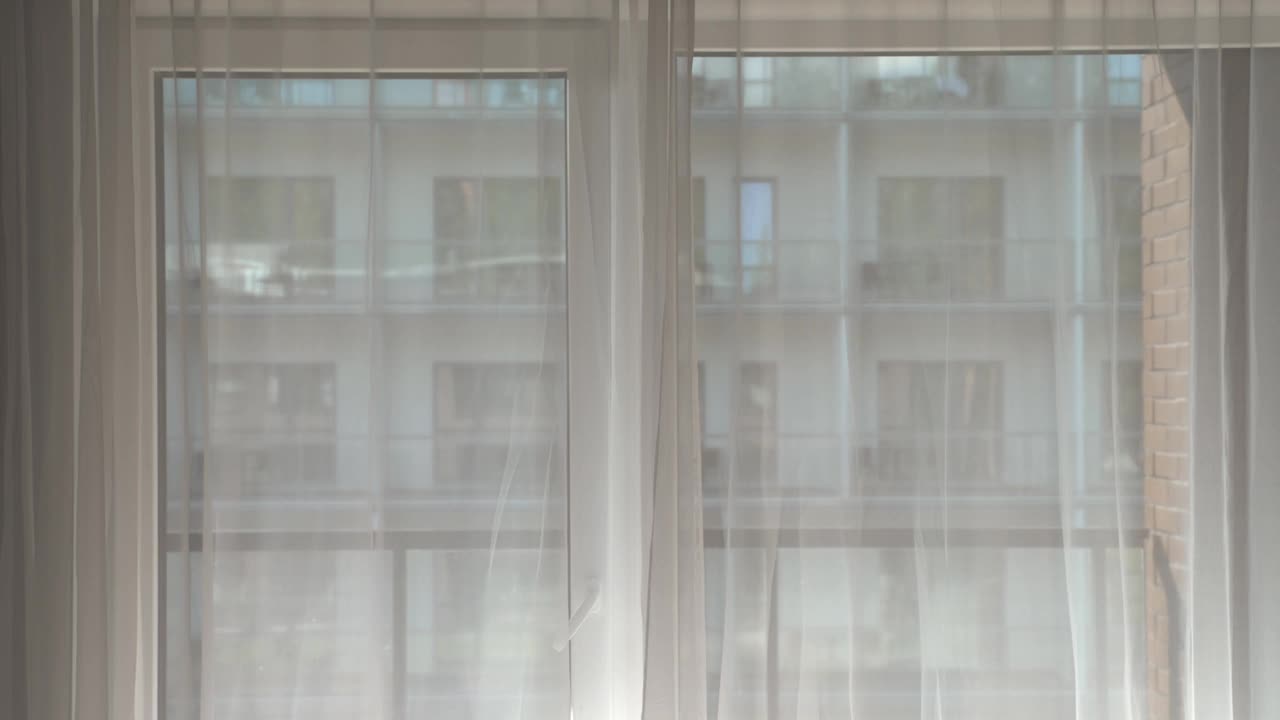 一个女人在酒店房间拉开窗帘。视频素材