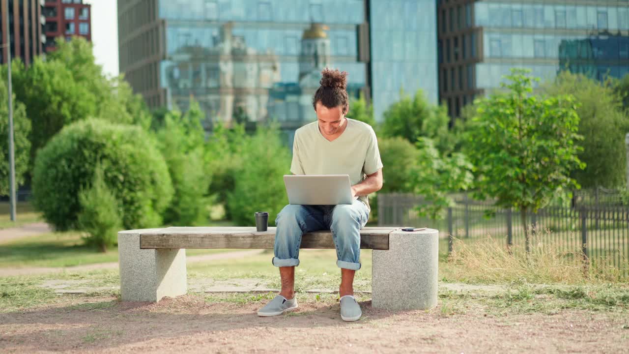 年轻人用笔记本电脑远程工作，关上电脑，坐在户外叹息和思考。男性企业家，自由职业者或学生完成工作视频素材