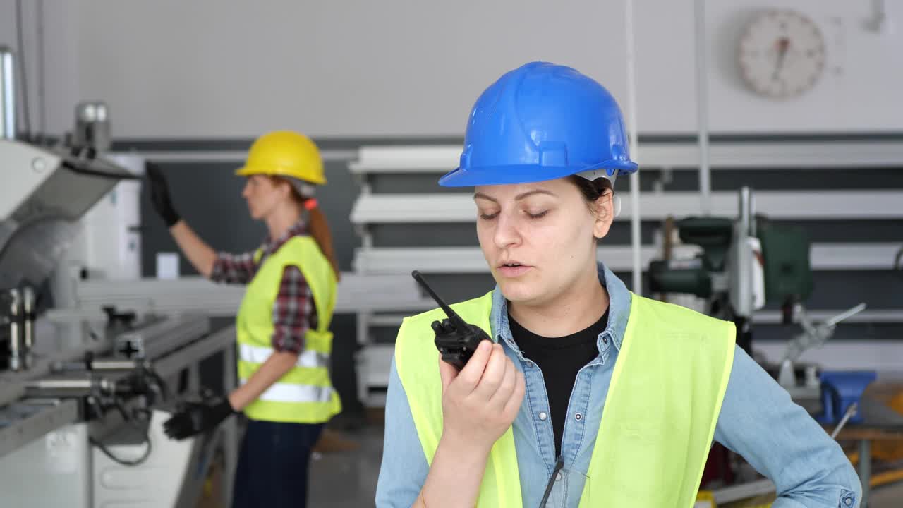 女工在工厂工作，穿戴防护工作服和头盔视频素材