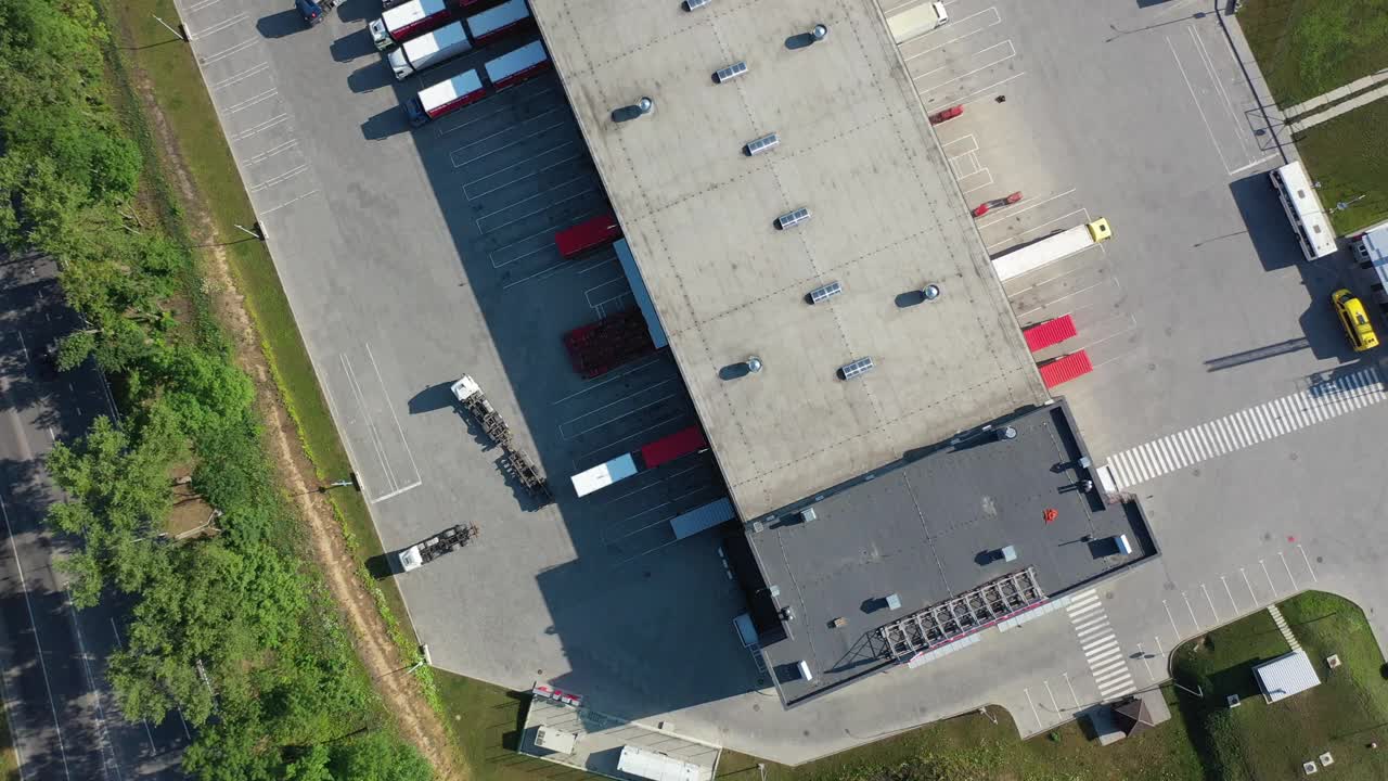 货物仓库鸟瞰图。工业城市区域的物流中心。物流中心装载卡车的鸟瞰图视频下载