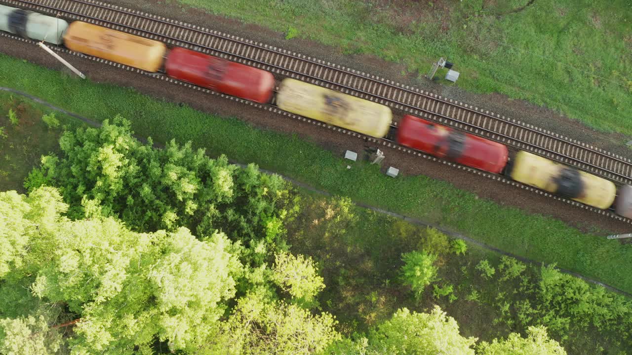 雾蒙蒙的日出时分，火车在铁轨上行驶。鸟瞰图视频素材
