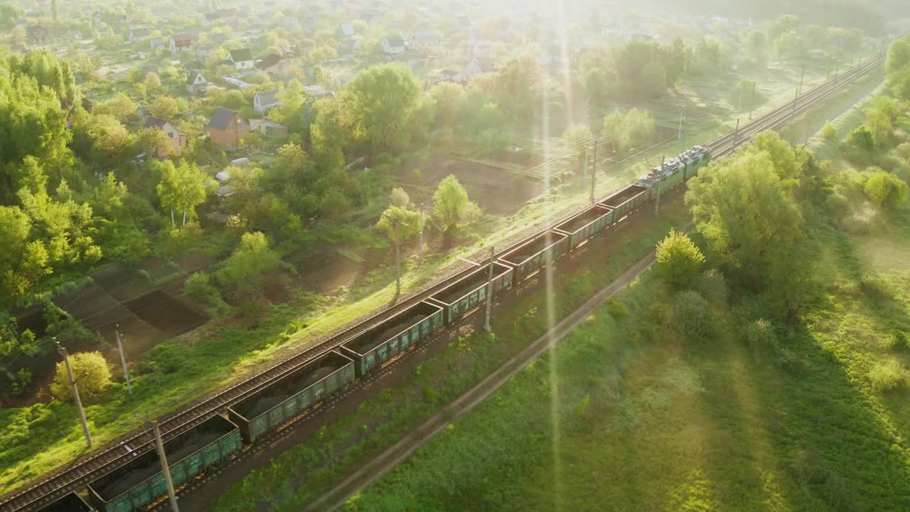 雾蒙蒙的日出时分，火车在铁轨上行驶。鸟瞰图视频素材